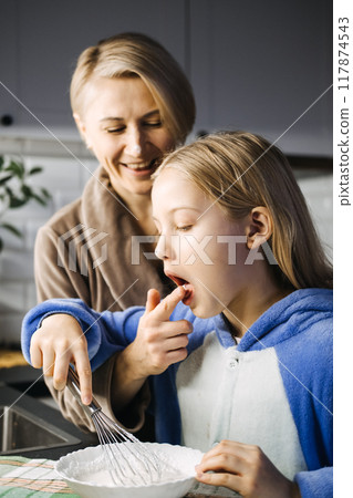 Mother and daughter baking Christmas cookies together, holiday traditions, family bonding, festive kitchen, creating memories, holiday spirit, Christmas preparation. Mother and daughter baking Christmas cookies together, holiday traditions, family bonding, festive kitchen, creating memories, holiday spirit, Christmas preparation. 117874543