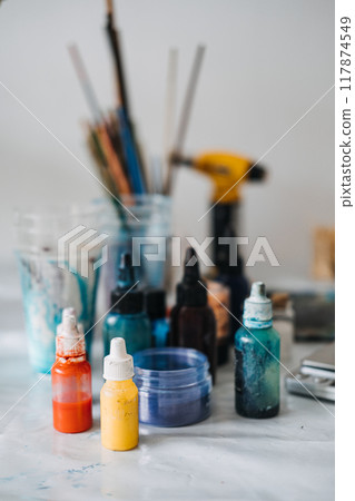 Creating vibrant epoxy resin art with various pigments and tools in a DIY workspace 117874549