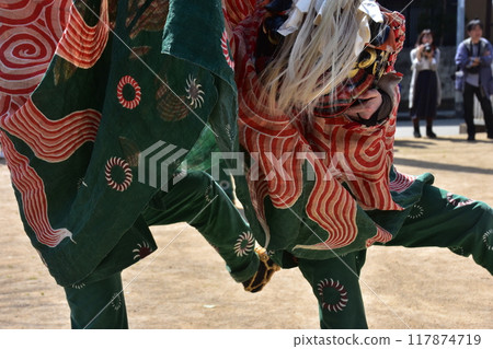 Takayama City, Gifu Prefecture, Japan: Traditional performing arts at the Takayama Spring Festival. Lion dance dedicated to the shrine. People wearing festival costumes and shaking the lion's face. Takayama City, Gifu Prefecture, Japan: Traditional performing arts at the Takayama Spring Festival. Lion dance dedicated to the shrine. People wearing festival costumes and shaking the lion's face. 117874719