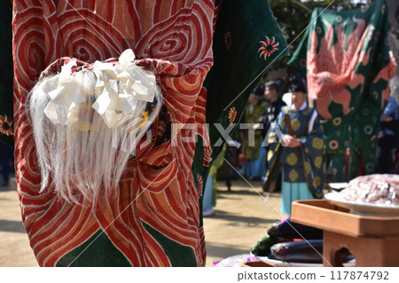 Takayama City, Gifu Prefecture, Japan: Traditional performing arts at the Takayama Spring Festival. A lion dance dedicated to a shrine. A lion dancing with its face swaying and watched by a Shinto priest. 117874792