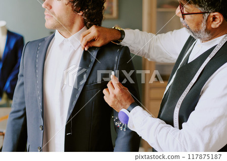 Professional Indian stylist marking suit while customer standing still 117875187