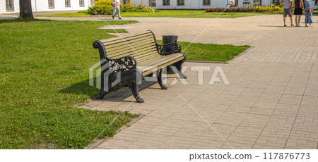 One wooden bench in RETRO style in the recreation area of the city park, summer day 117876773