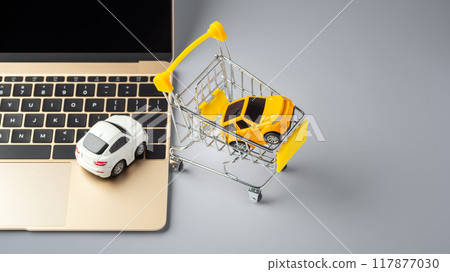 Online buying, selling car concept, toy car on laptop with shopping cart on grey table Online buying, selling car concept, toy car on laptop with shopping cart on grey table 117877030