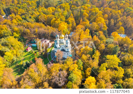 Golden leaves dance around a quaint church nestled in a vibrant autumn forest during a sunny afternoon Golden leaves dance around a quaint church nestled in a vibrant autumn forest during a sunny afternoon 117877045