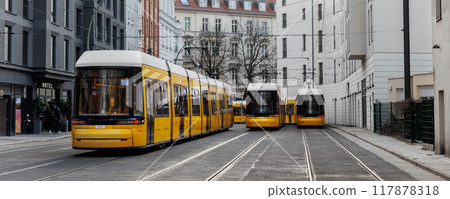 Scenic evening view many modern yellow tram car parked at street station Berlin Mitte central district at dusk warm sunset. Urban european transport commute cityscape Germany scene background Scenic evening view many modern yellow tram car parked at street station Berlin Mitte central district at dusk warm sunset. Urban european transport commute cityscape Germany scene background 117878318
