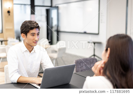 一名男子在開會時看著對方的眼睛並傾聽對方所說的話 一名男子在開會時看著對方的眼睛並傾聽對方所說的話 117881695