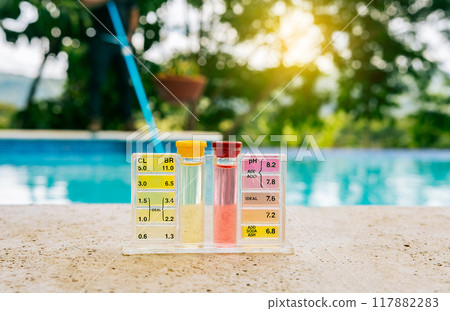 Tester kit to measure chlorine and ph in swimming pools. Pool water PH tester kit on the edge of the swimming pool Tester kit to measure chlorine and ph in swimming pools. Pool water PH tester kit on the edge of the swimming pool 117882283