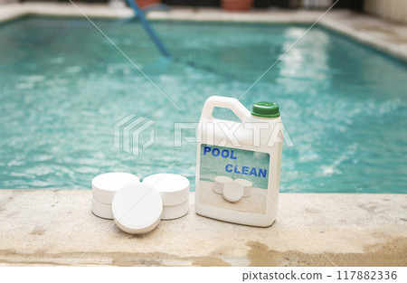 Pool cleaning chlorine tablets kit, pool cleaning chlorine tablets close up on the edge of a swimming pool, pool sanitizing chlorine tablets concept 117882336