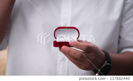 Wedding rings close in a man's hand Wedding rings close in a man's hand 117882440