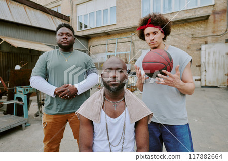 Biracial bros looking at camera while hanging out together in backyard 117882664