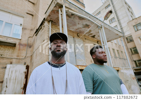 Bad guys standing next to old building in neighborhood Bad guys standing next to old building in neighborhood 117882672