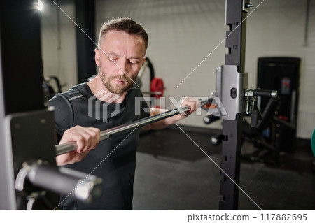 Highly skilled bodybuilder using Smith machine in gym 117882695