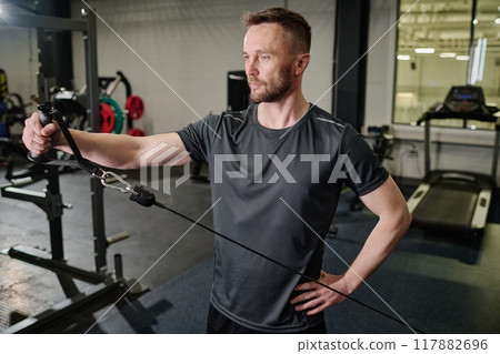 High angle shot of man doing shoulder exercise to develop muscles High angle shot of man doing shoulder exercise to develop muscles 117882696