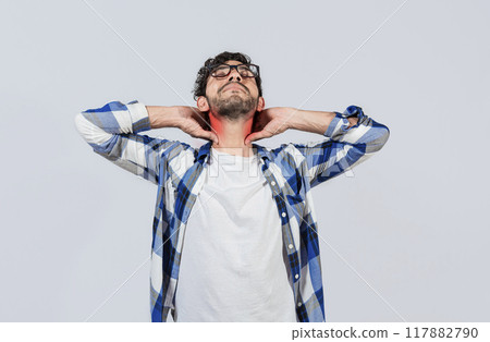 Young man with shoulder and neck problems, Person in pain rubbing his neck isolated, Concept of people with stress and neck pain problems. Tired guy with neck pain isolated 117882790