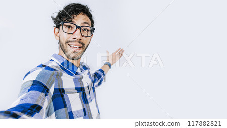 Man pointing back and presenting a product, Young man welcoming you isolated, person welcoming you with one hand. Friendly man inviting you to come Man pointing back and presenting a product, Young man welcoming you isolated, person welcoming you with one hand. Friendly man inviting you to come 117882821