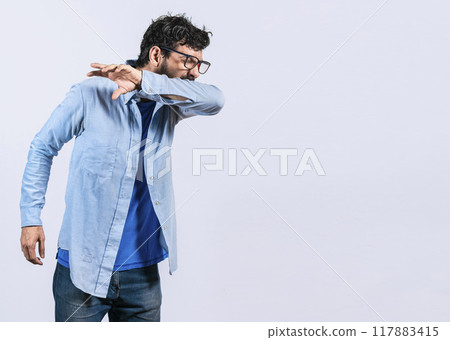 Beard man sneezing with his elbow, A guy sneezing with his elbow on isolated background, concept of man having a cold sneezing with his elbow 117883415