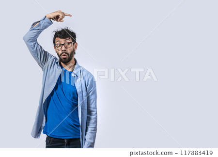 Surprised handsome man pointing to the side, Concept of latin man pointing a banner to the side, Surprised guy pointing a poster 117883419