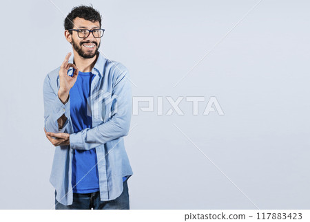 Man gesturing everything is ok, young man making ok gesture, Smiling man showing ok gesture looking at camera, expression of everything is fine. Man gesturing everything is ok, young man making ok gesture, Smiling man showing ok gesture looking at camera, expression of everything is fine. 117883423