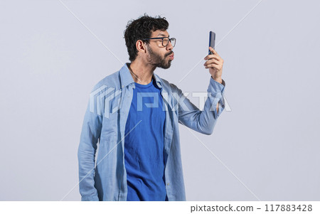 A man blowing kisses on the cell phone isolated, man taking selfie and blowing kisses on the cell phone, A guy blowing kisses on the phone, loving man sending kisses on the phone 117883428