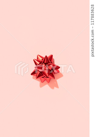 Christmas postcard wallpaper with red bow on pink in minimal style. Xmas holiday background 117883628