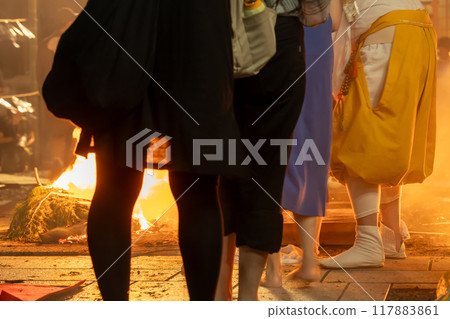 A monk guiding a fire walker at the Toka Kannon temple in Tsu City, Mie Prefecture 117883861