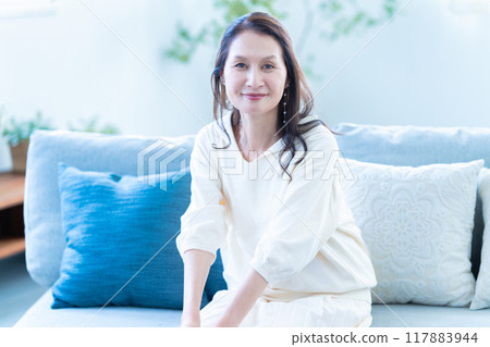 A stylish senior woman relaxing on the sofa A stylish senior woman relaxing on the sofa 117883944