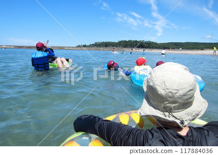 Family playing at the beach 117884036