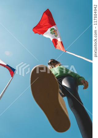 A woman walking into to two flags, Peru and Chile flags. Migration concept A woman walking into to two flags, Peru and Chile flags. Migration concept 117884942
