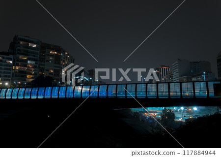 Bridge with a blue light shining on it, Miraflores, Lima Peru. City skyline in the background Bridge with a blue light shining on it, Miraflores, Lima Peru. City skyline in the background 117884944