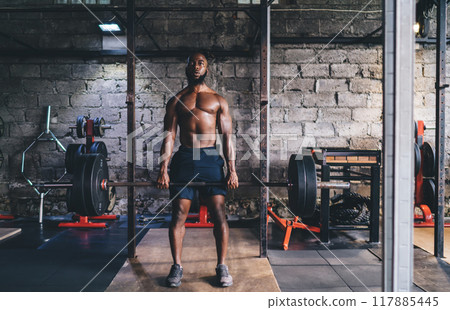 Muscular man in sportswear lifting barbell with heavy weights 117885445