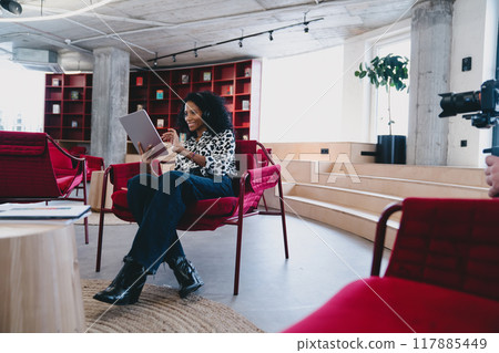 Joyful Black businesswoman in 30s, engaging with digital tablet Joyful Black businesswoman in 30s, engaging with digital tablet 117885449