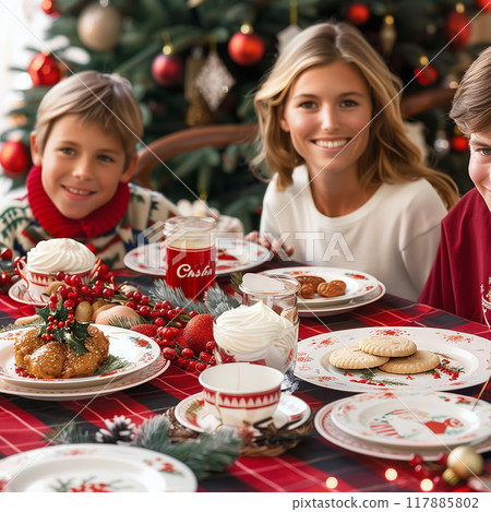A family is sitting at a table with a Christmas tree in the background 117885802