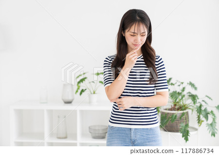 一個年輕的女人在房間裡放鬆 一個年輕的女人在房間裡放鬆 117886734