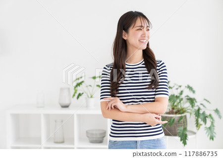 一個年輕的女人在房間裡放鬆 一個年輕的女人在房間裡放鬆 117886735