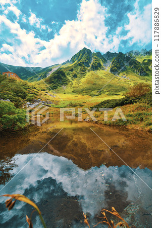 A pond with clouds rising in early autumn 117886829