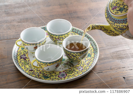 將烏龍茶倒入中國茶具中 將烏龍茶倒入中國茶具中 117886907