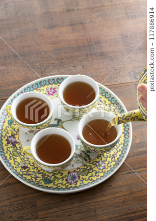 將烏龍茶倒入中國茶具中 將烏龍茶倒入中國茶具中 117886914