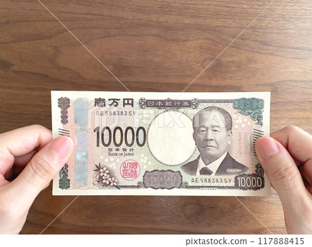拿著 10,000 日元鈔票的女人的手 117888415