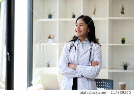 Portrait of confident young female doctor standing in clinic Portrait of confident young female doctor standing in clinic 117889260