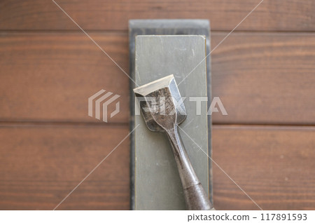 A well-used chisel and natural whetstone 117891593
