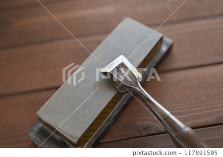 A well-used chisel and natural whetstone 117891595