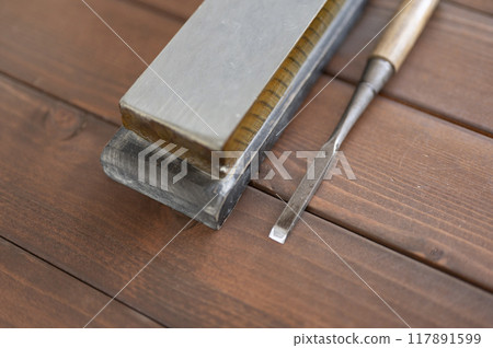 A well-used chisel and natural whetstone 117891599