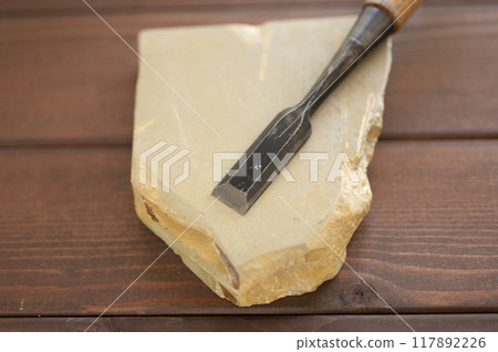 A well-used chisel and natural whetstone A well-used chisel and natural whetstone 117892226