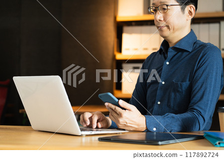 Middle-aged man facing a computer 117892724