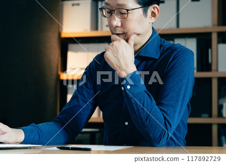 Middle-aged man facing a computer 117892729