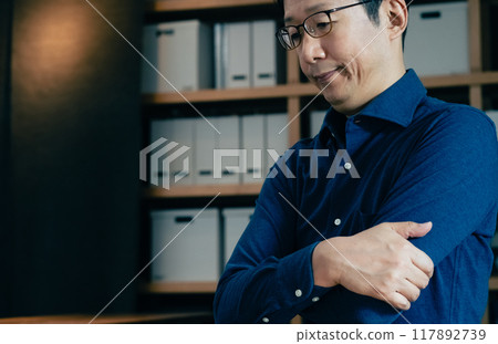 Middle-aged man facing a computer Middle-aged man facing a computer 117892739