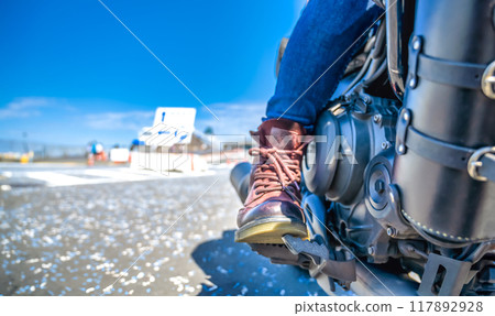 The feet of a female rider touring Yokohama on a large cruiser bike The feet of a female rider touring Yokohama on a large cruiser bike 117892928