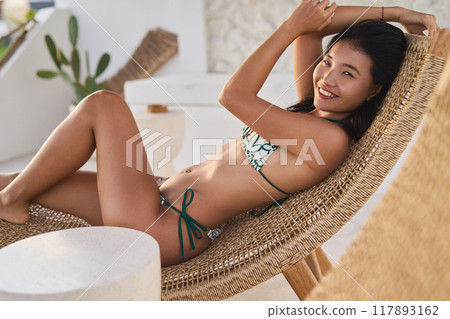Relaxing on Vacation in a Bikini at a Sunny Resort Relaxing on Vacation in a Bikini at a Sunny Resort 117893162