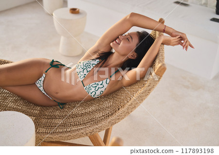 Summer Tan. Relaxing Woman in Bikini Sunbathing at Luxurious Resort Summer Tan. Relaxing Woman in Bikini Sunbathing at Luxurious Resort 117893198