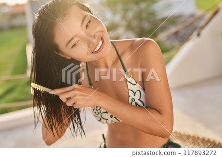 Hair. Woman Combing Wet Hair Outdoors Embracing Natural Hair Care Routine Hair. Woman Combing Wet Hair Outdoors Embracing Natural Hair Care Routine 117893272